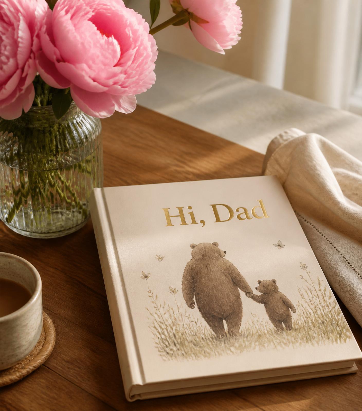 Hi, Dad hardcover children's book on a warm wooden table beside pink peonies